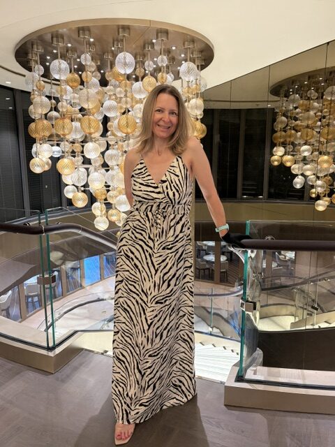 Frau Zebra-Maxikleid eleganter Kronleuchter EXPLORA III Lobby