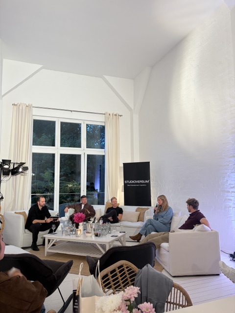 Podiumsdiskussion Studioversum fünf Gäste weißen Sofas